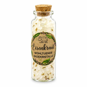 Liebevoll &uuml;berreichtes Florex Geschenkset Eisenkraut auf festlich gedecktem Tisch mit Kerzenlicht, nat&uuml;rlichen Wellnessprodukten und dekorativer Geschenkverpackung in gem&uuml;tlicher Atmosph&auml;re