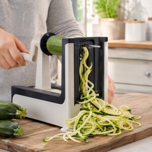 Original LURCH Spiralschneider beim Schneiden frischer Zucchini auf Holzbrett mit Gem&uuml;sespiralen